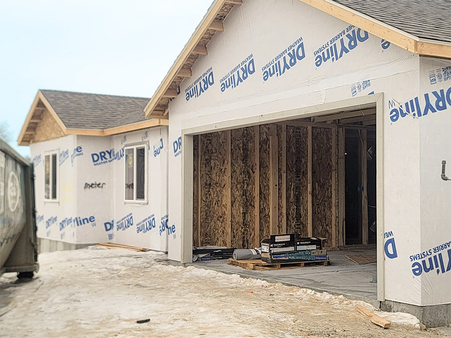 home under construction with house wrap framing and roof complete of 200 Willow - the Edison by Smart Dwellings